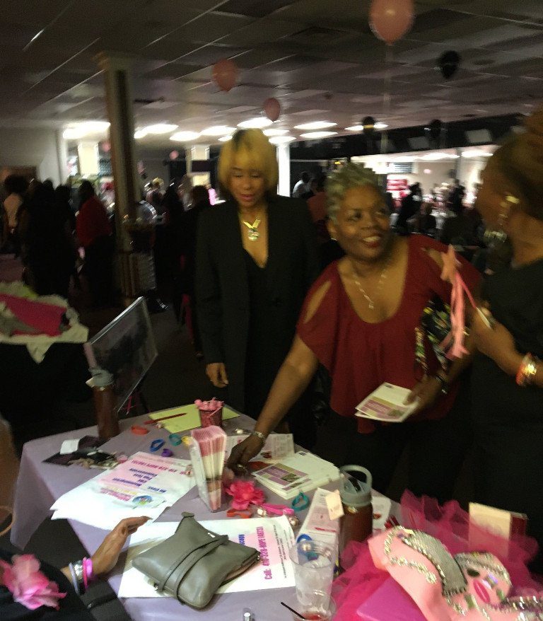 Women at event table with brochures